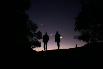 A night scape with the silhouette of two people against the sky.