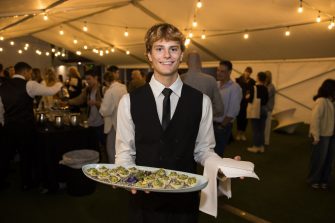 Waiter at the Creative Conversations event serving canapes on a Mud Australia platter
