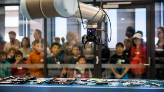 Robotic arm with children in the background
