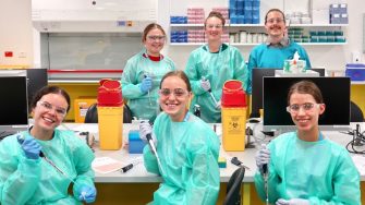 A group photo of SciX students in a lab on campus