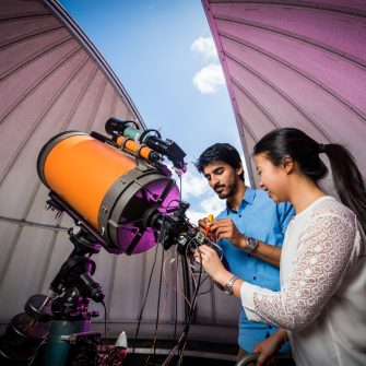 Two students using a telescope