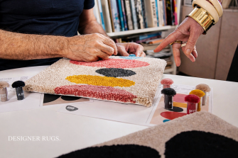 hands pointing at designer rugs