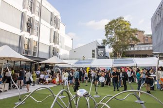 A group of people gathered in the courtyard of the UNSW Paddington campus to attend the opening night of the A&D Annual 2023 exhibition. 