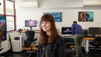 Student using virtual reality headset and controls in 3D Visualisation Aesthetics Lab.