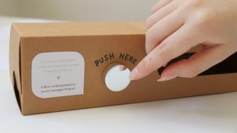 Finger pushing button on cardboard box