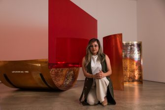 Vedika Rampal kneels in front of her work 'Forms of a Fermenting Fantasy', 2023