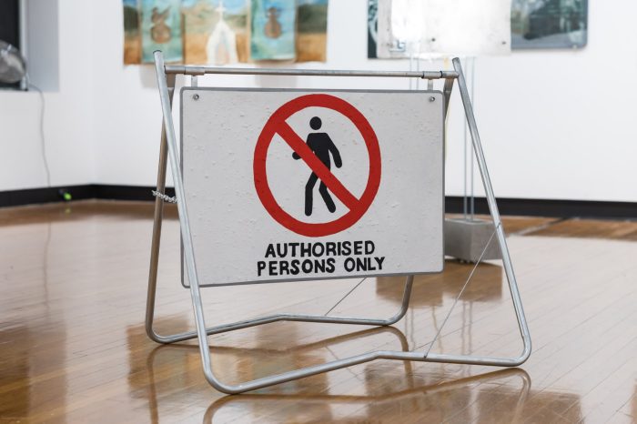 Allyson Brown, ‘Boundary St’ 2026. Wall mounted sign: Spray paint on metal, 50cm x 183cm. Triangle ‘give way’ sign: Acrylic and ochre on metal, 80cm x 80cm (80 cm each side). Free standing ‘authorised persons only’ sign: Acrylic and ochre on metal, 104cm x 93cm x 70cm.