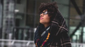 Young african woman walking in the city on the snowy day