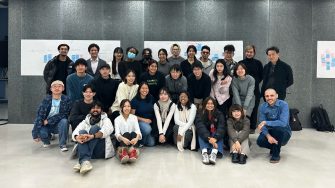 Students and faculty posing for a photograph following an exhibition.