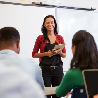 Teacher listening to students at an adult education class
