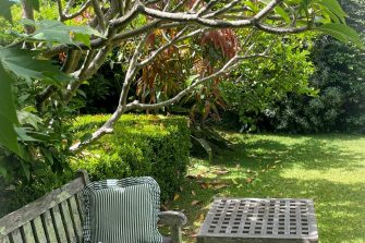 Garden bench with a cushion and a book