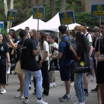 Students holding signs with degrees listed