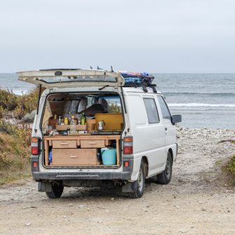 Van with kitchenette in boot parked on beach