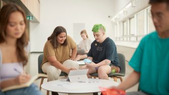 Art and design students discussing work inside the Red Center build enviroment study space.