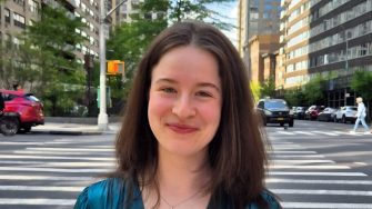 Grace Truman smiles in front of a New York zebra crossing