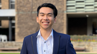 Student William Nguyen stand on the UNSW Library Lawn with a broad smile on his face.