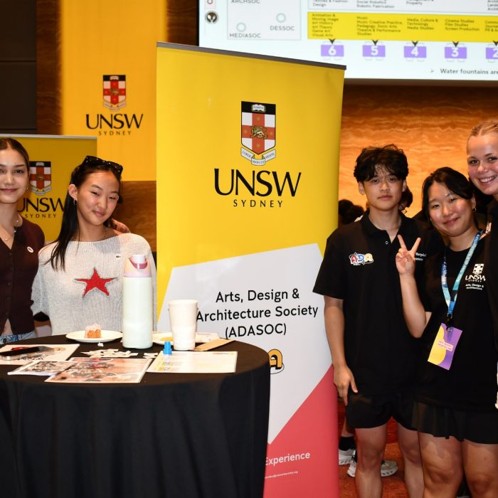 Students smile in front of a sign in front of Specialisation Showcase 2026