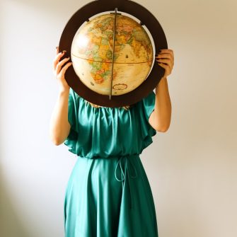 a woman holding a globe in front of her face