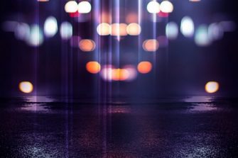 Reflection on the wet asphalt, the lights of the night city. Dark background with abstract bokeh, rays of light.