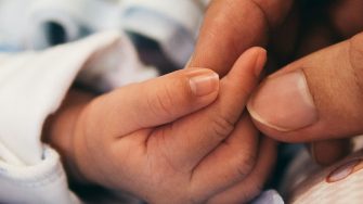 Person holding baby hand