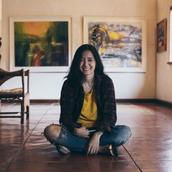 A woman smiling and seating on the floor
