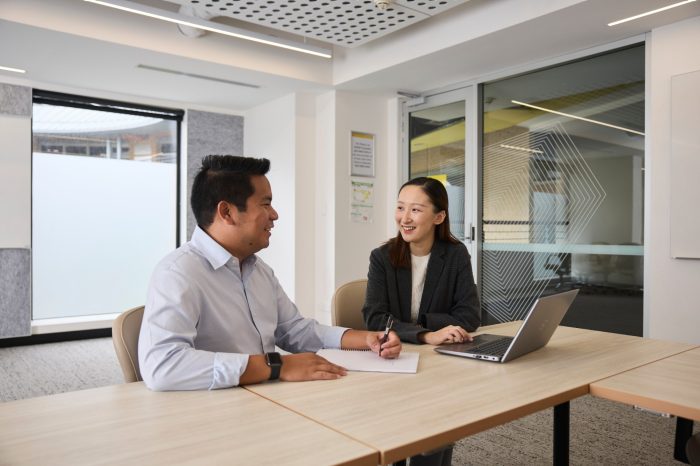 AGSM students working together from a laptop in a classroom on campus
