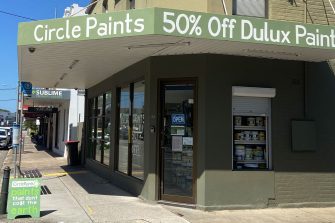Exterior of the Circle Paints store, with signage advertising discounted Dulux paints and environmentally conscious paint products.