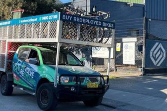 A ute, with a cage packed with bicycles, with Revolve ReCycling signage on it