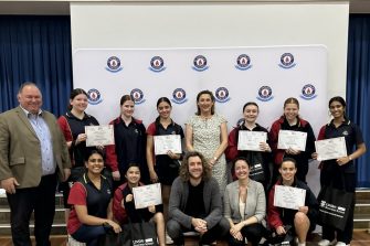 Students holding certificates with UNSW staff at a Playconomics presentation at St Patricks College