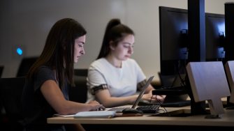 Students studying on computers in the business school computer lab.
