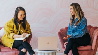 Two women sitting on chair having a discussion