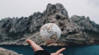 Hand with a globe shot near a lake