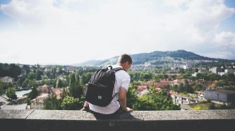 Young man sitting on wall