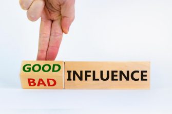 Businessman turns cubes and changed words 'bad influence' to 'good influence'. Beautiful white background. 
