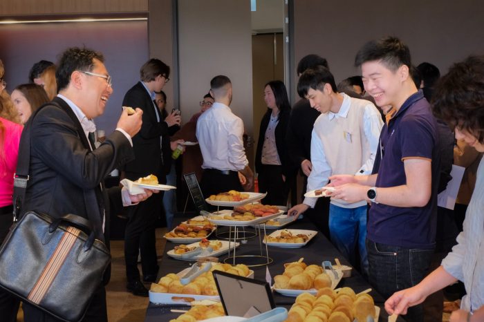 Workshop attendees smile over a table of food.