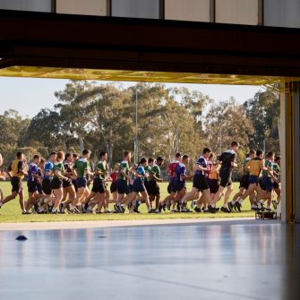 A large group of students jogging past a large doorway