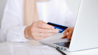 Woman entering credit card details on a laptop