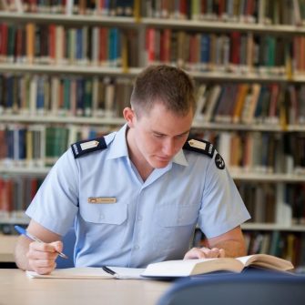 Student in uniform working in library