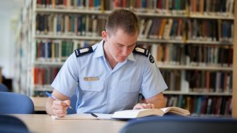 Student in uniform working in library