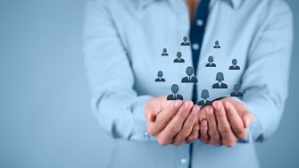 Graphic depicting business person with people avatars  in hand