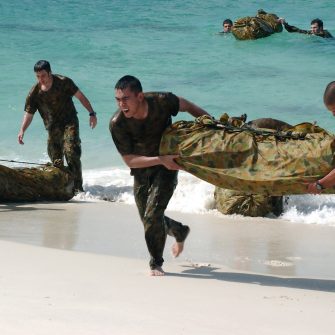 Military personnel landing on a beach