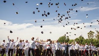 UNSW Canberra graduates throwing their military hats into the air
