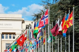 Multicoloured flags in front of United Nations Palais in Geneva, Switzerland