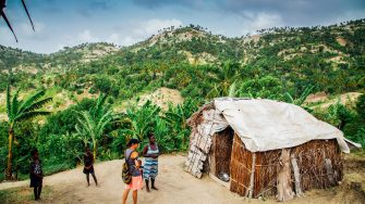 People standing in front of a hut