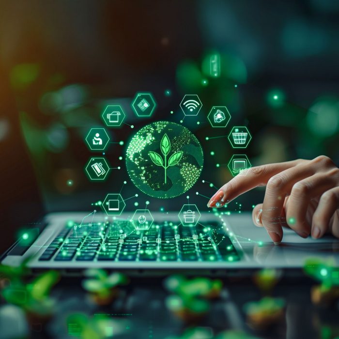 A hand engages with a laptop, generating a holographic display of eco-friendly icons and a leaf symbol, representing sustainable technology and our net zero goals