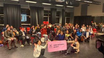 UNSW Nintendo Society members posing in front of their Arc sign and enjoying themselves