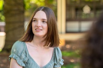 A group of students chatting while sitting on Library Lawn on Kensington Campus