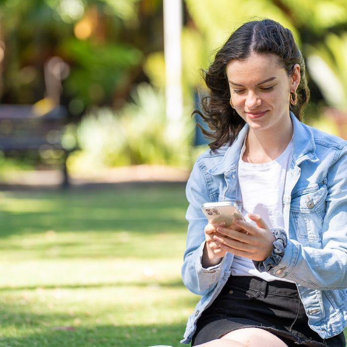 A student sitting on the Michael Birt Lawn