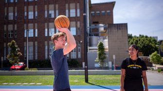 Students playing basketball at The Village Green