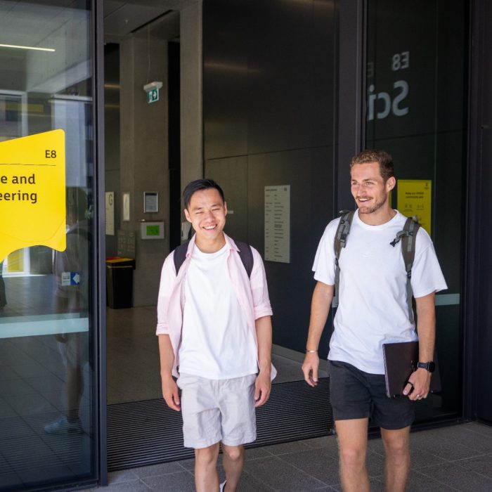 Two students chatting while exiting the Science & Engineering building on UNSW Kensington Campus